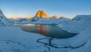 Pic du midi d'Ossau au coucher de soleil avec le lac et la neige. Tableau photo. Pyrénées, montagne..