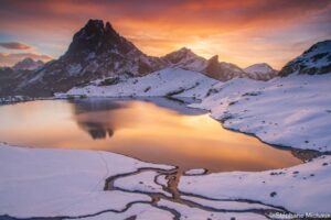 Pic du midi d'Ossau et reflet dans le lac d'Ayous entouré de neige avec un ciel d'aurore merveilleux l'automne. Tableau photo. Pyrénées, montagne.